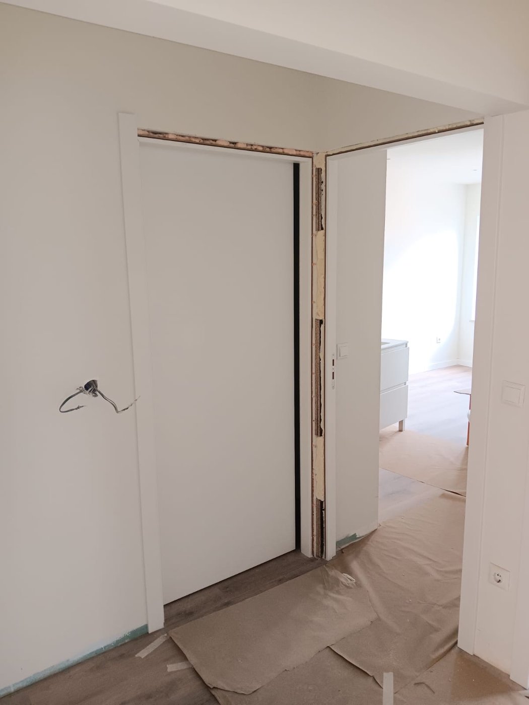 Portas interiores brancas, com aros a condizer e ferragens em inox.