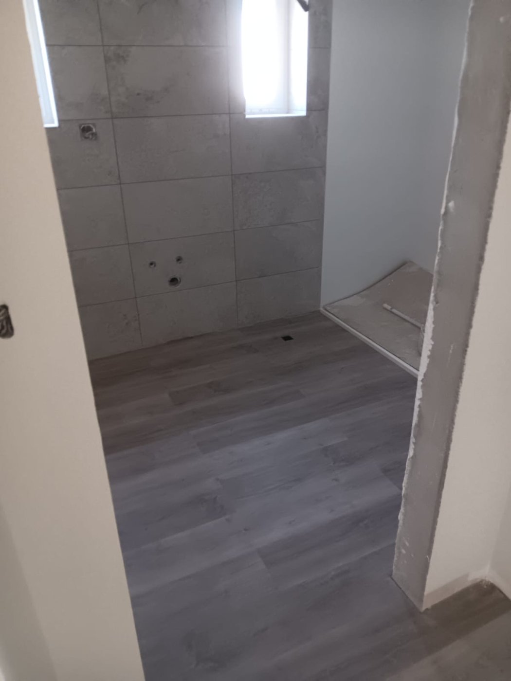 Casa de banho: revestimento cerâmico em tom pedra.